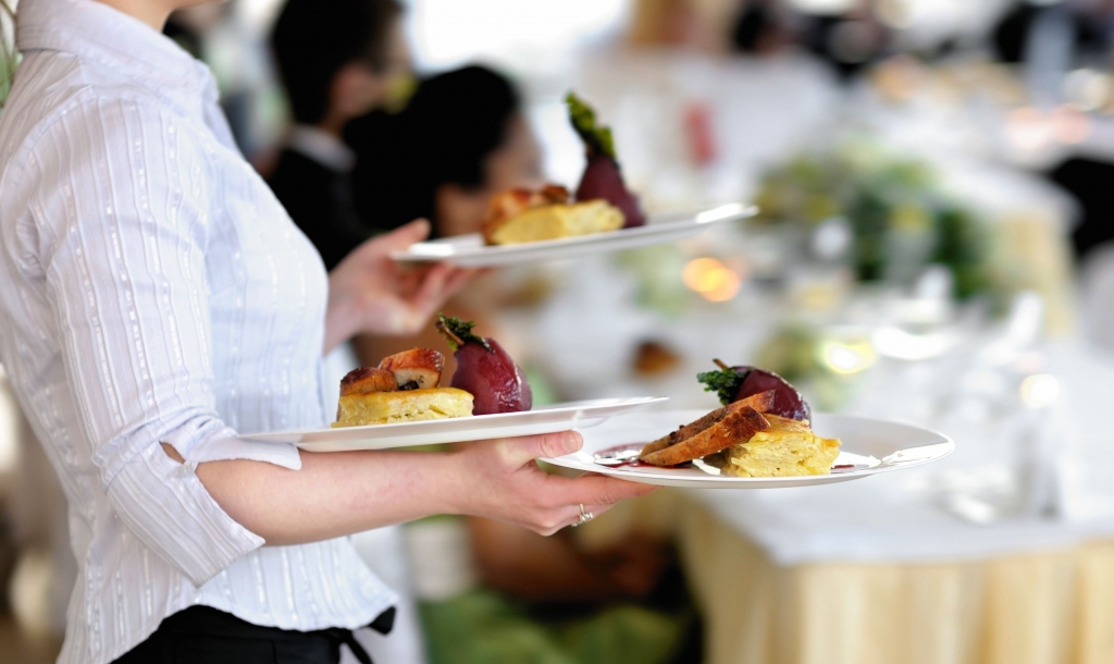 server carrying plates of food at an event