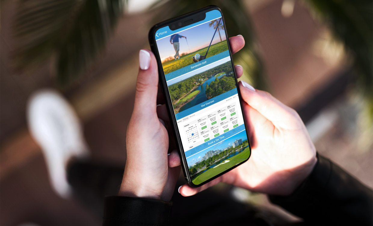 woman on her cell phone looking at the Sandestin app