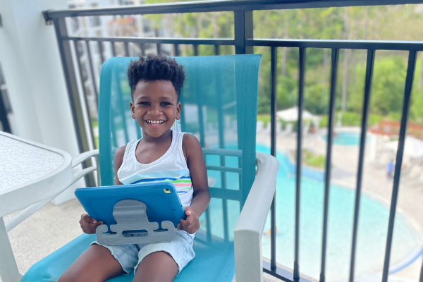 smiling Child on balcony with ipad