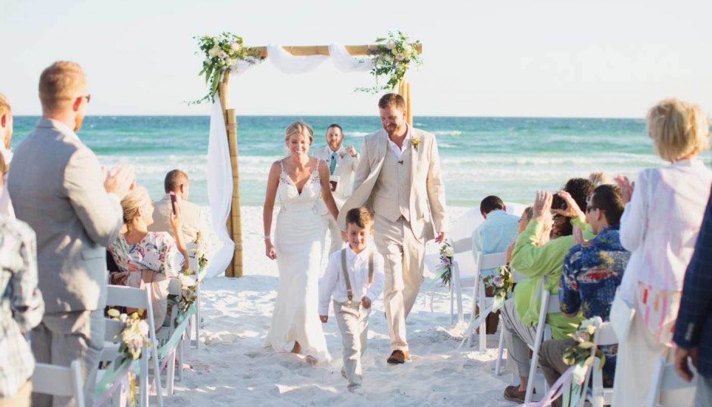 Bride and groom walking down beach wedding isle