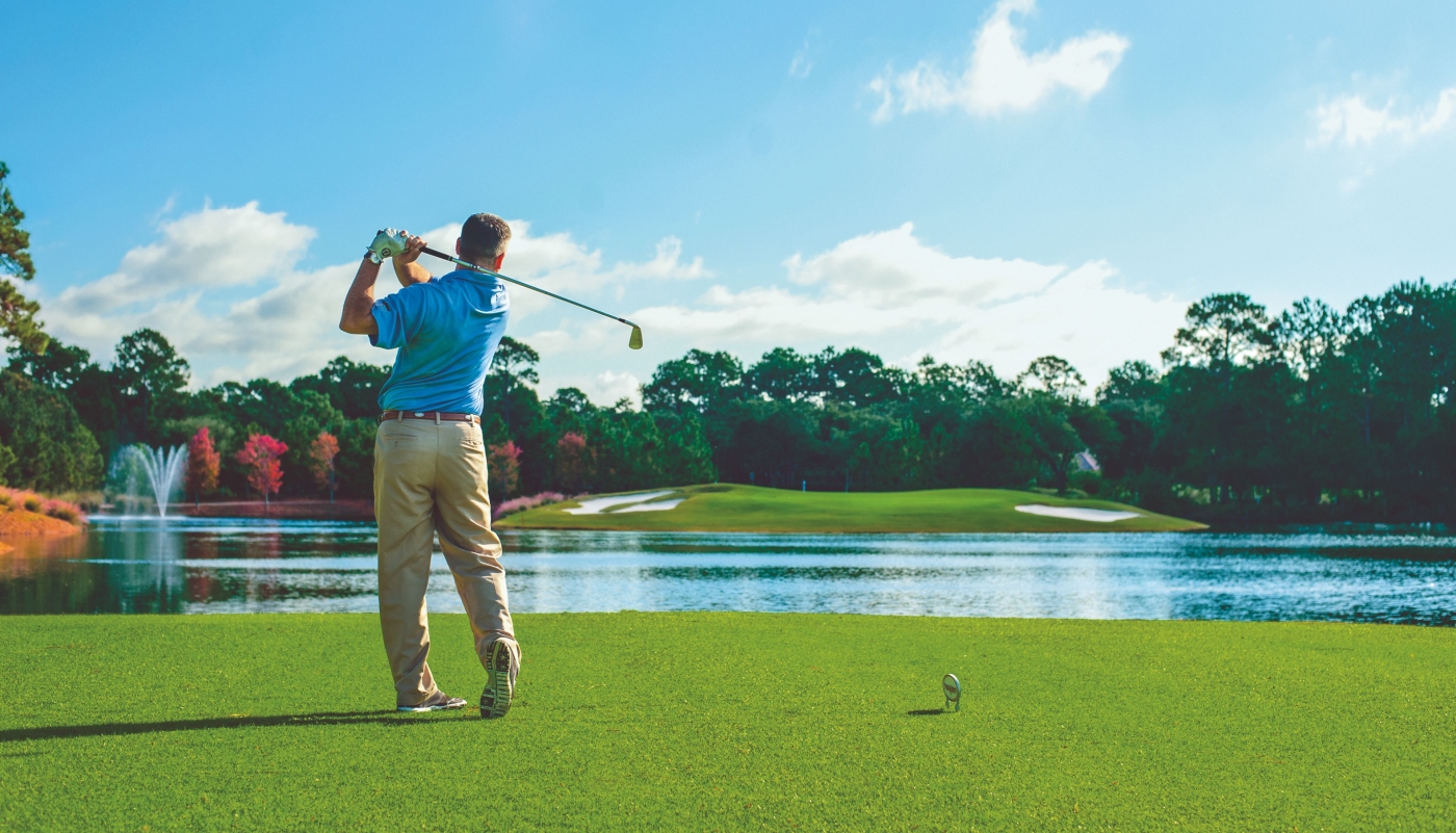 a man tees off at Raven golf course