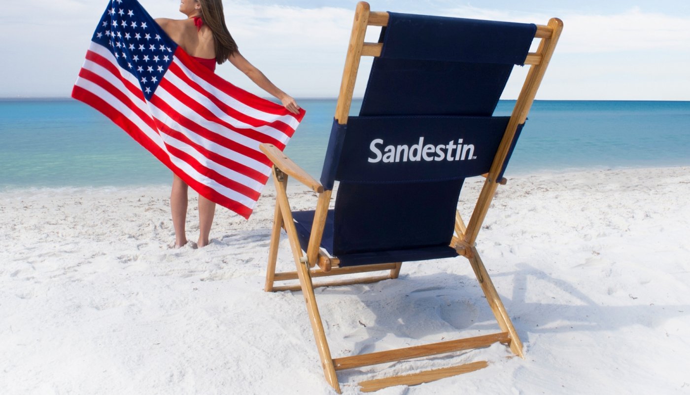 Woman on the beach with an American flag and beach chair