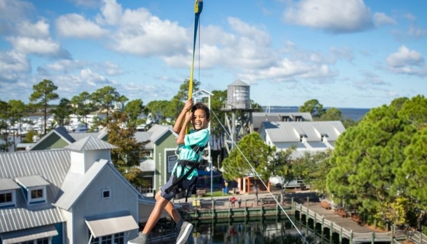 Kid zip lining across Baytowne Wharf