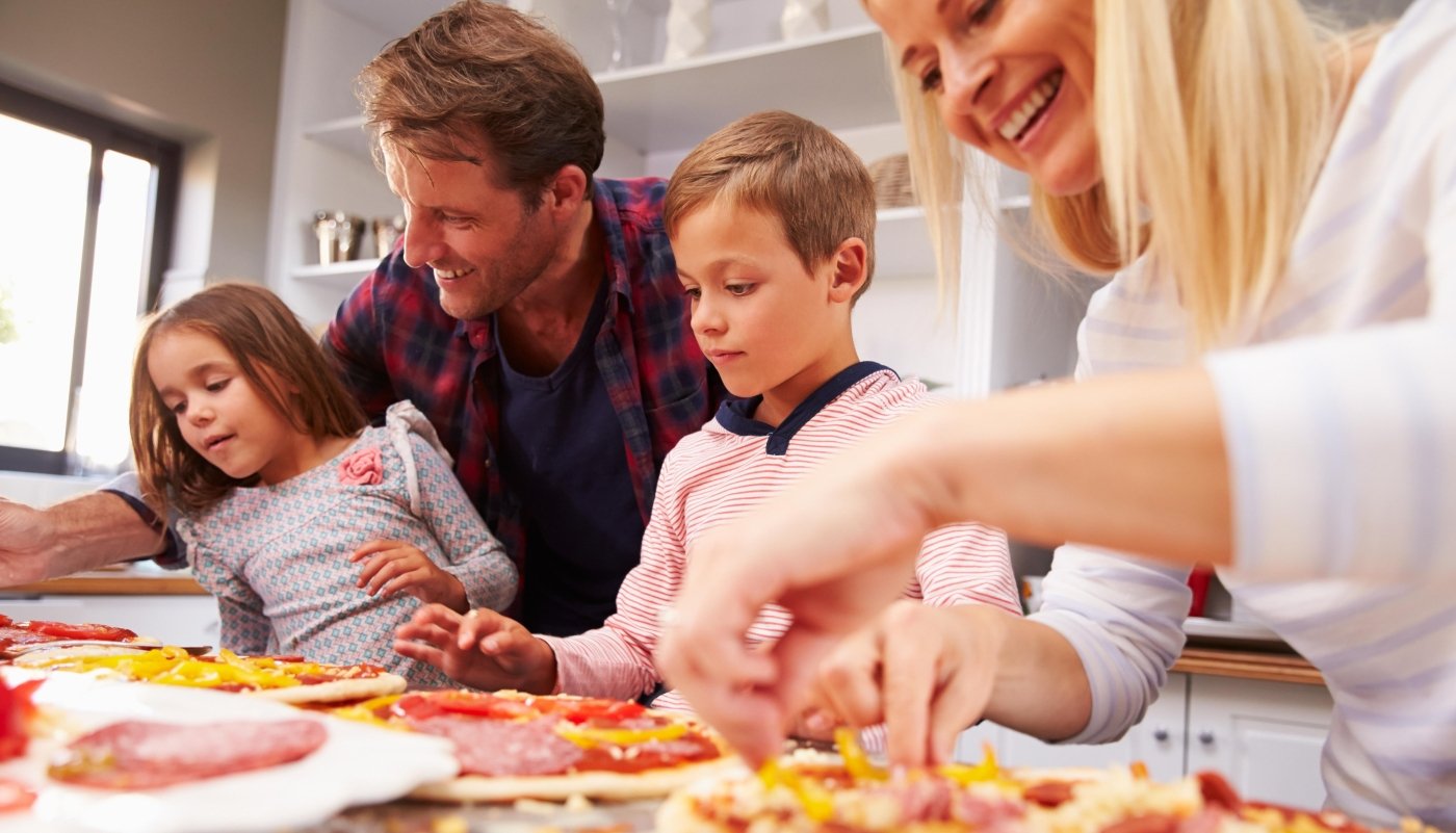 family making homemade pizza
