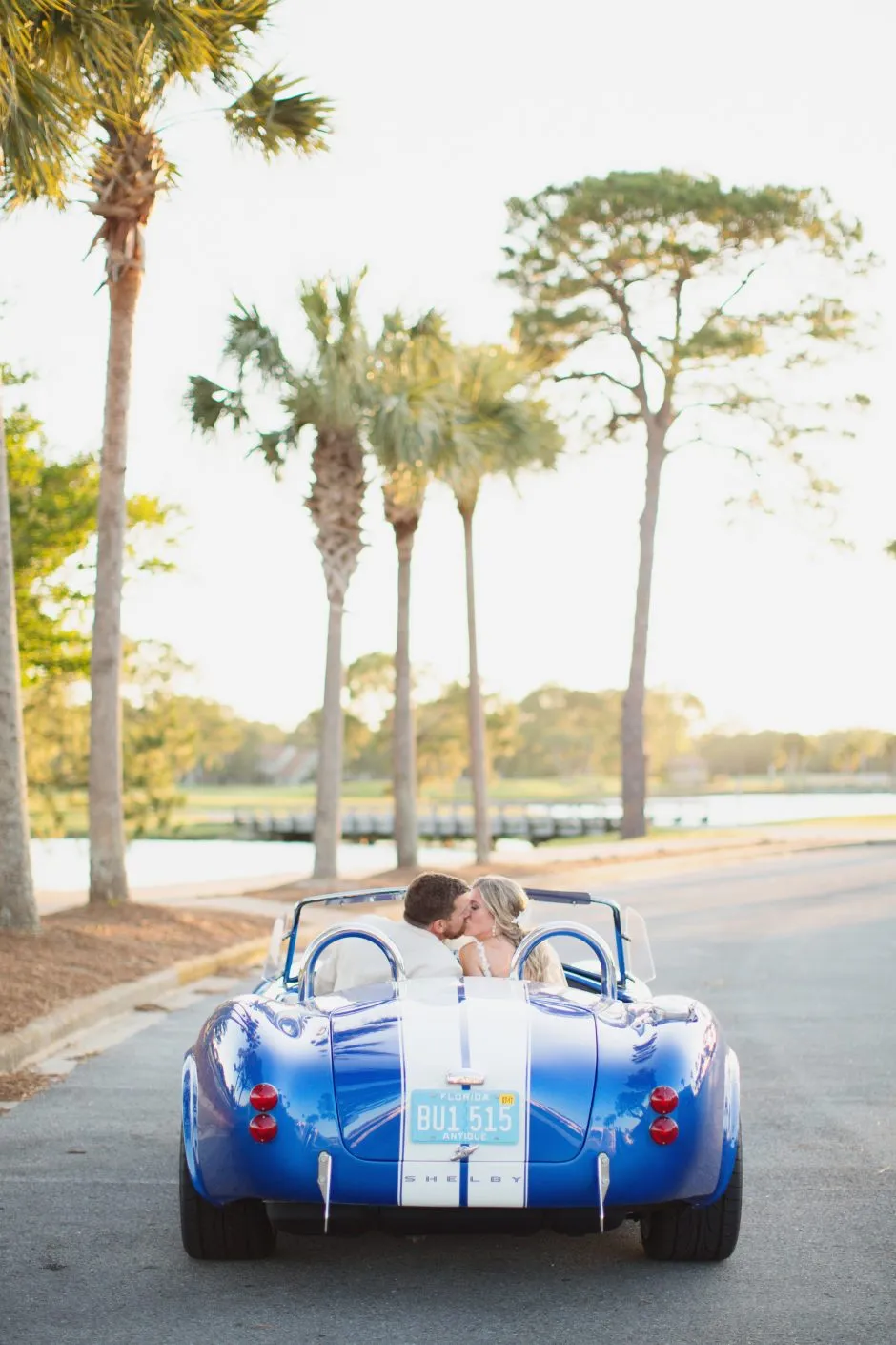 Bride and groom kissing in convertible 