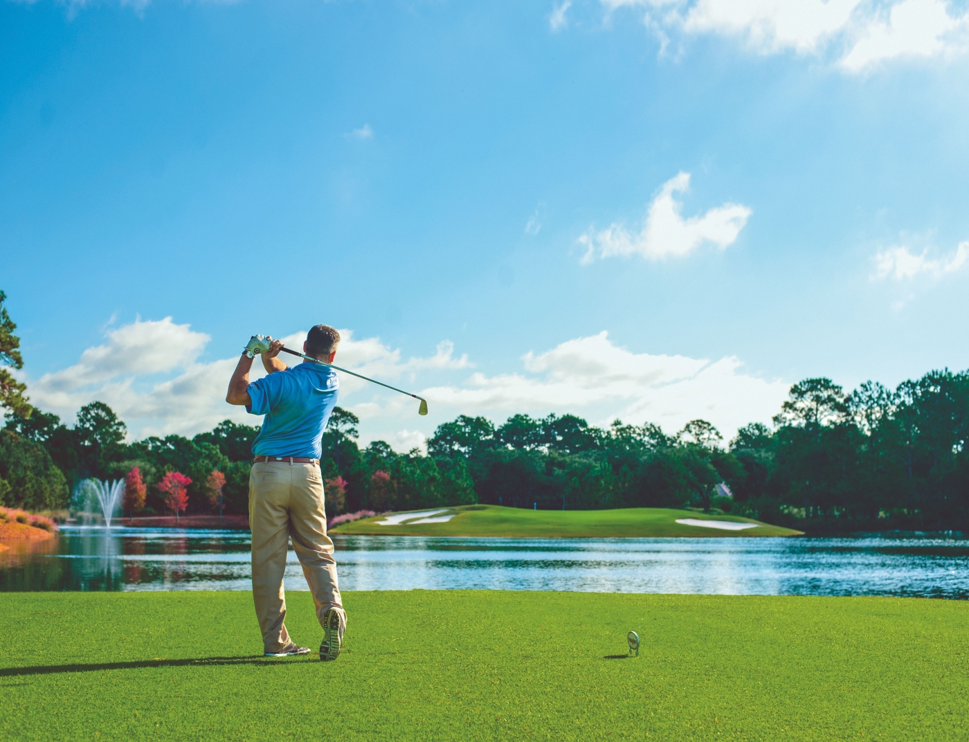 a man tees off at Raven golf course