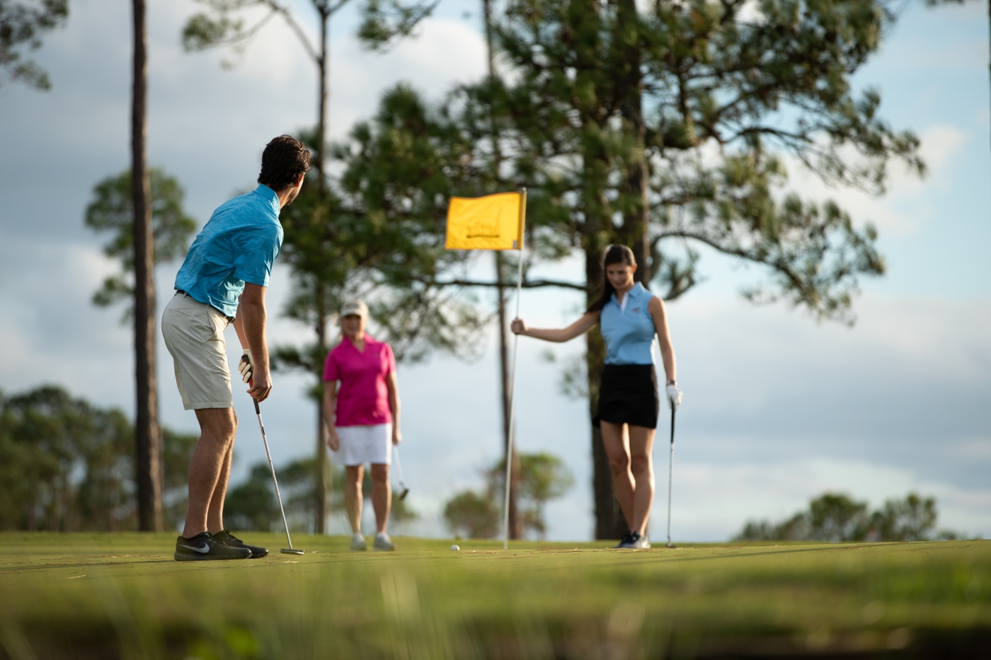 three people playing golf