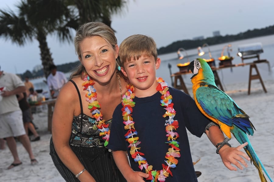 Mother and son posing with a parrot