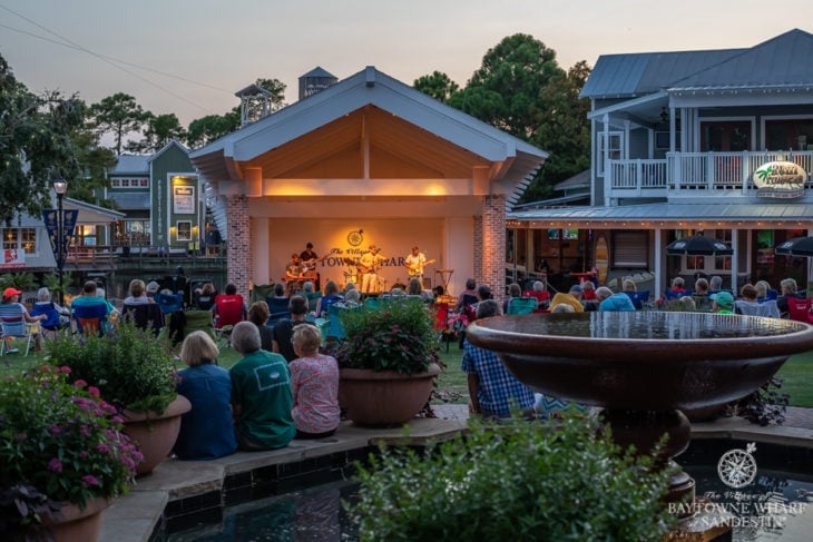 People sitting on lawn chairs watching an outdoor concert