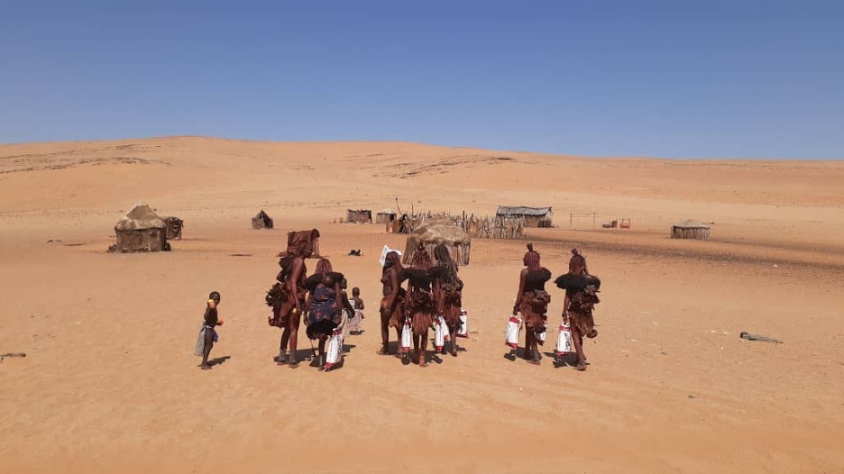 Members of the Himba Tribe carrying supplies