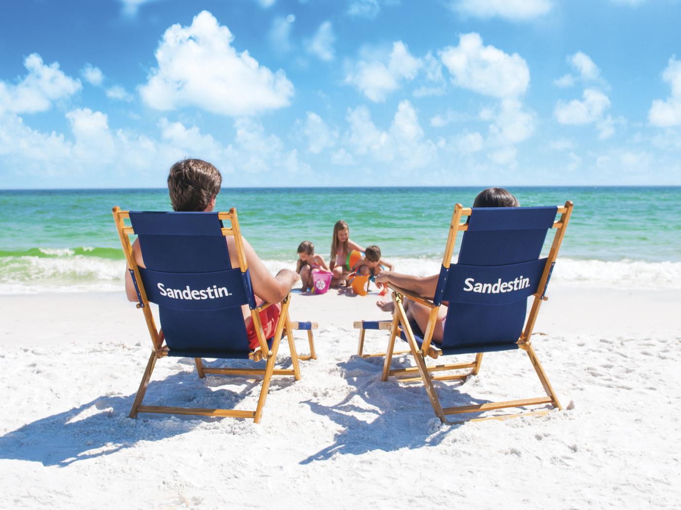 Couple sitting on beach with kids