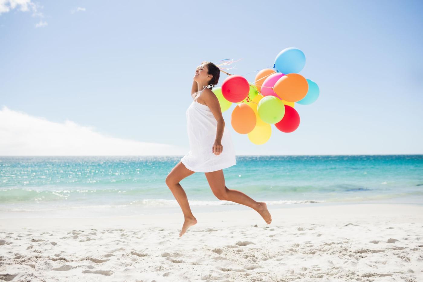 Young woman on beach with balloons