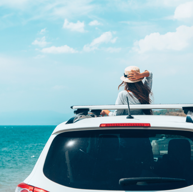 Woman in a car by the beach.