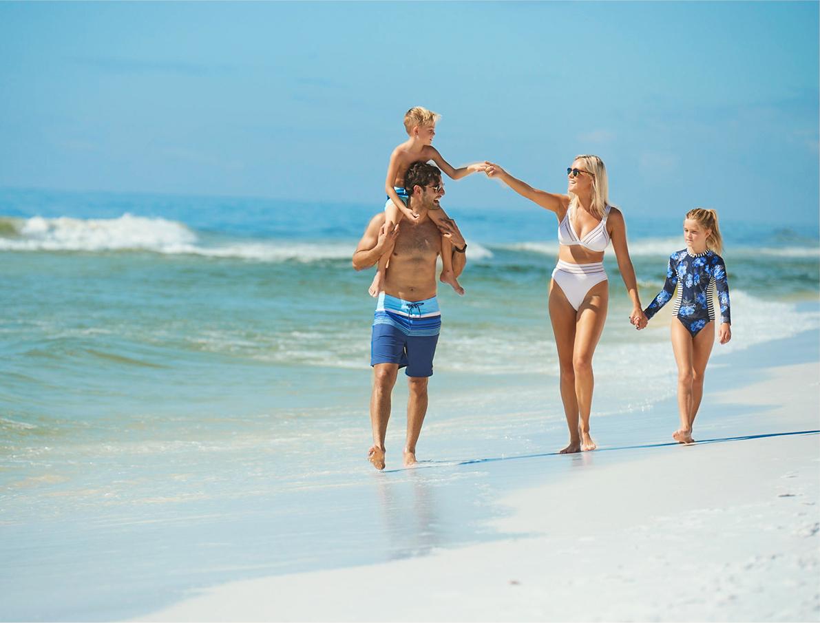 Family walking on the beach together.