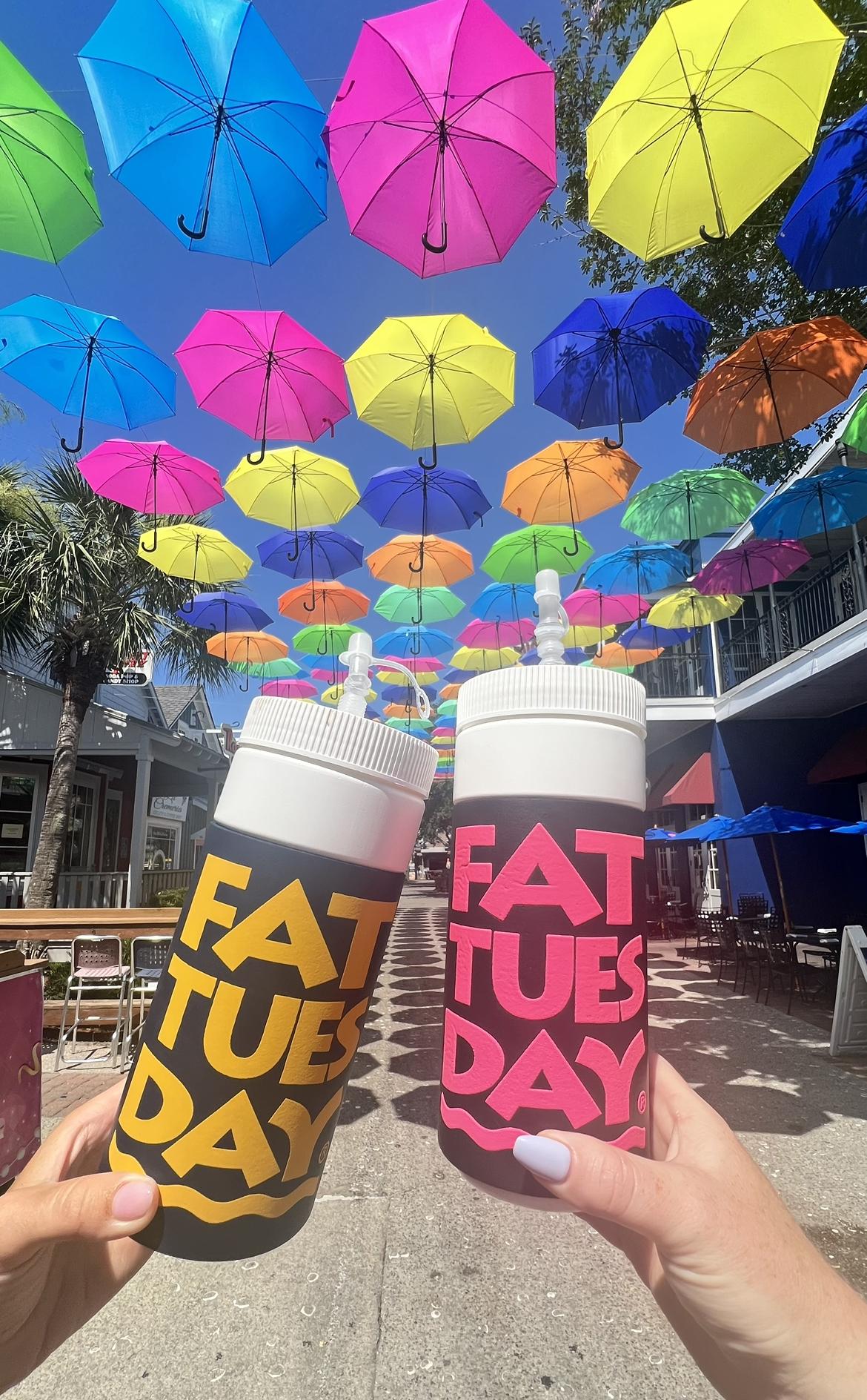 Souvenir cups in front of a colorful umbrella display.