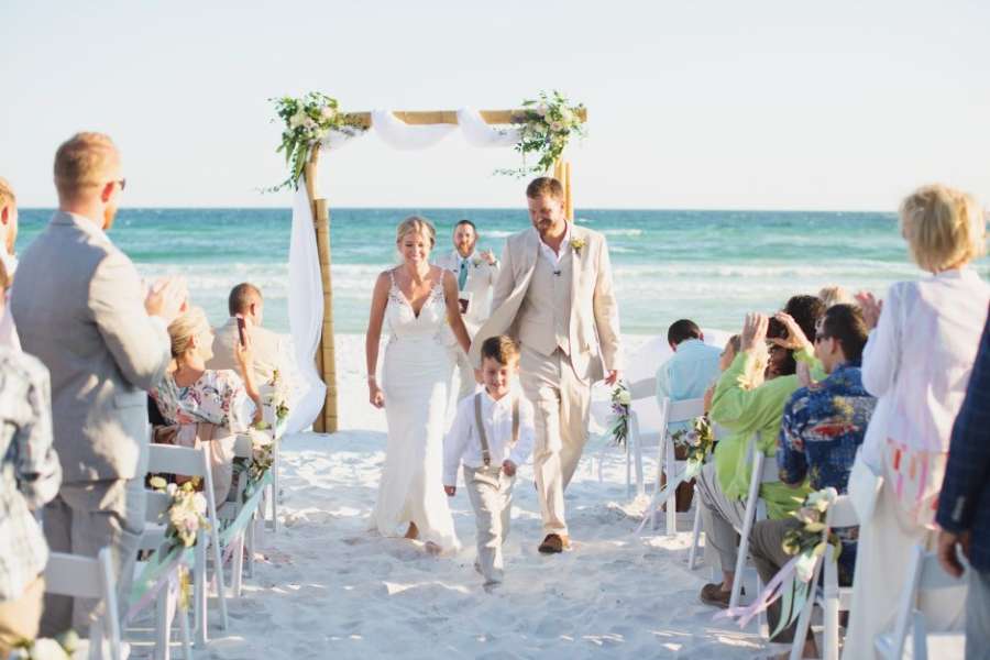 Bride and groom walking down beach wedding isle
