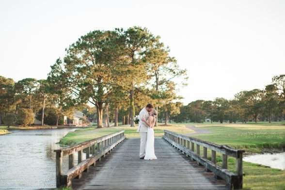 Bride and groom kissing on bridge