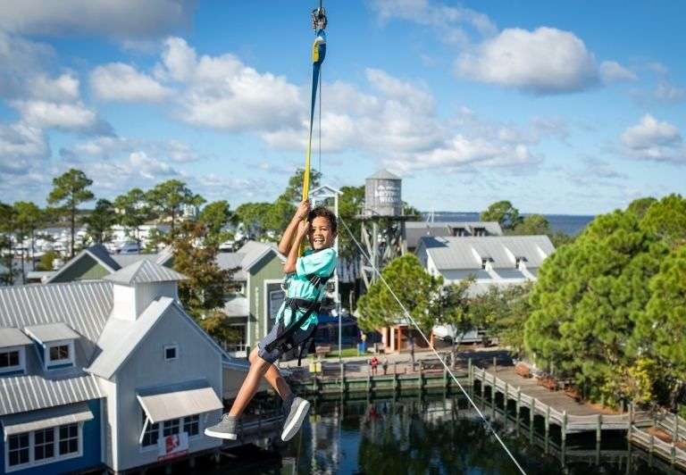 Kid zip lining across Baytowne Wharf