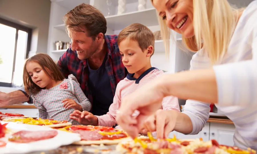 family making homemade pizza 