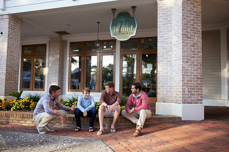 Men sitting in front of store