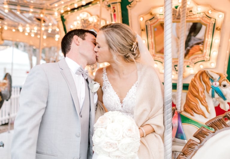 bride and groom kissing on a carousel