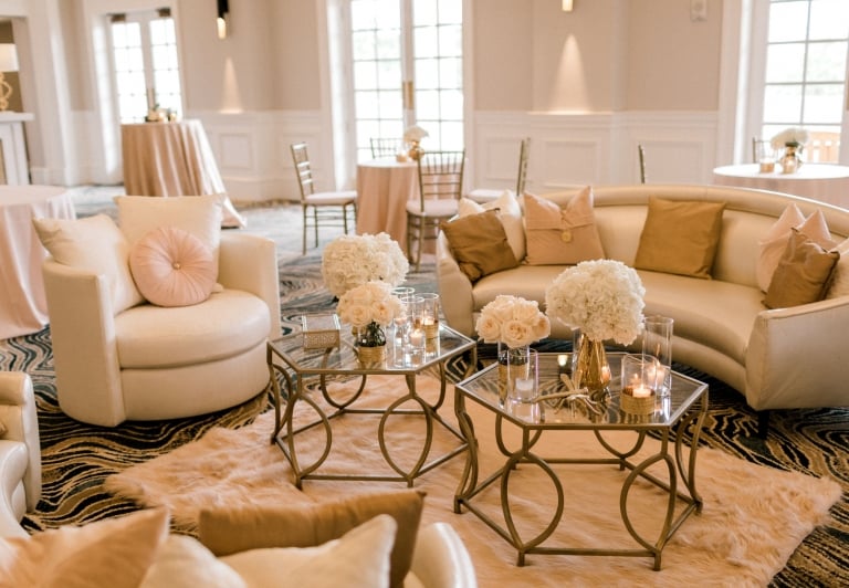 the azalea ballroom decorated for a wedding, with glass tables white couches and flowers as decorations