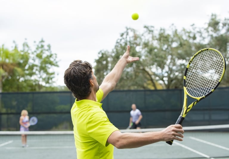 man serving a tennis ball