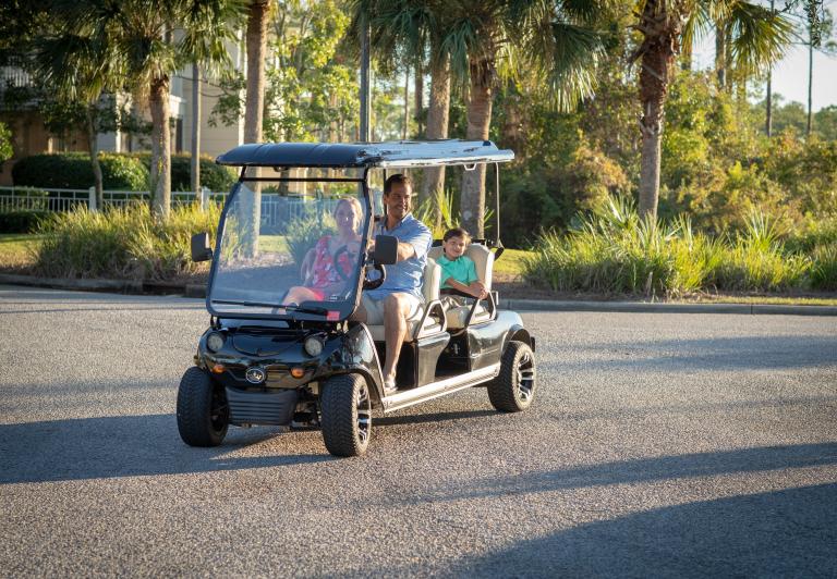 family riding in a golf cart