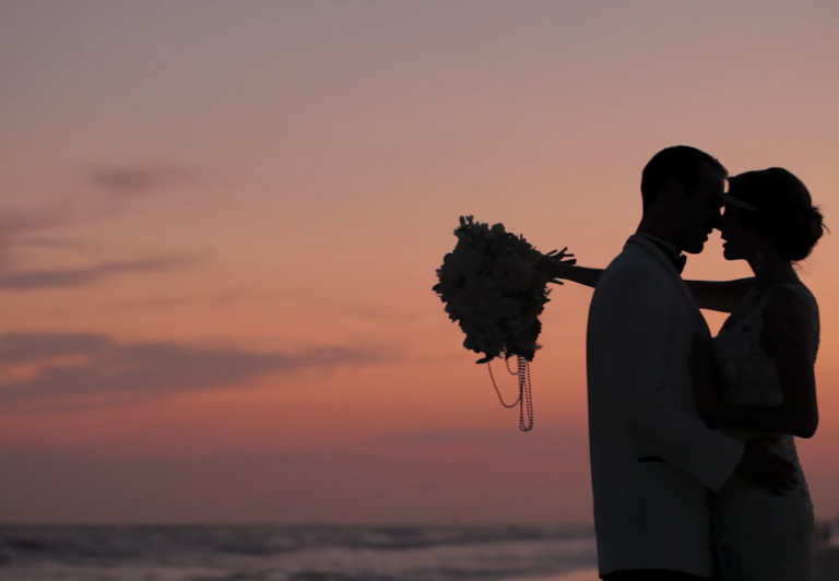 Bride and groom kissing at sunset