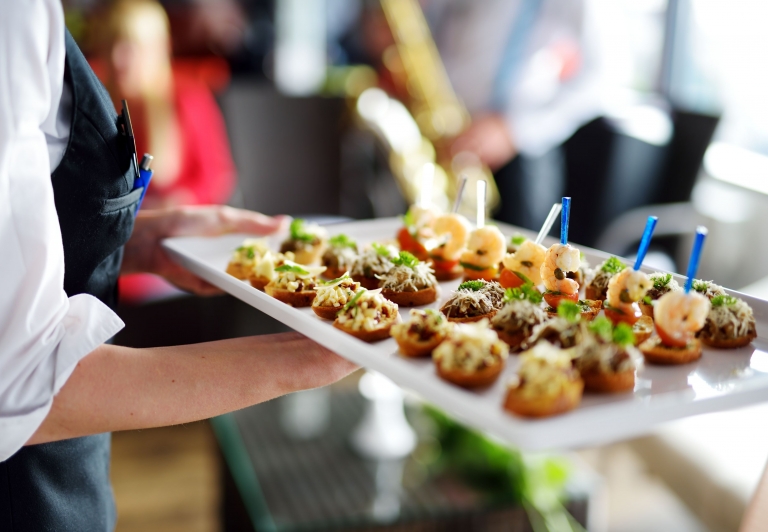 a server carries a tray of appetizers