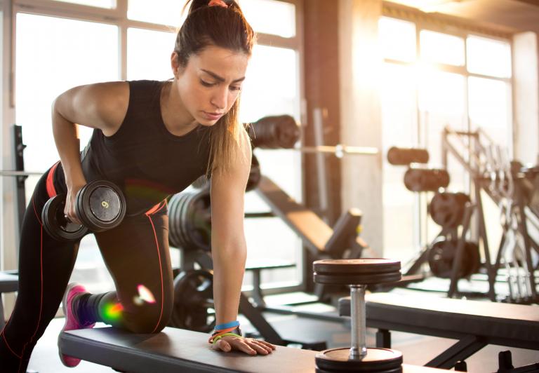 woman doing rows with hand weights