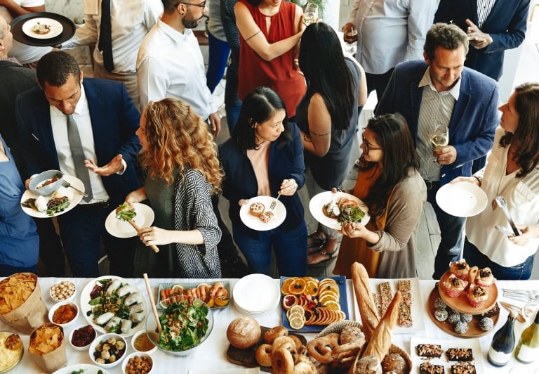 catering table at a business event with people standing by