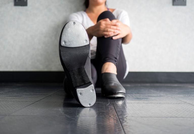 woman sitting on the ground wearing tab shoes