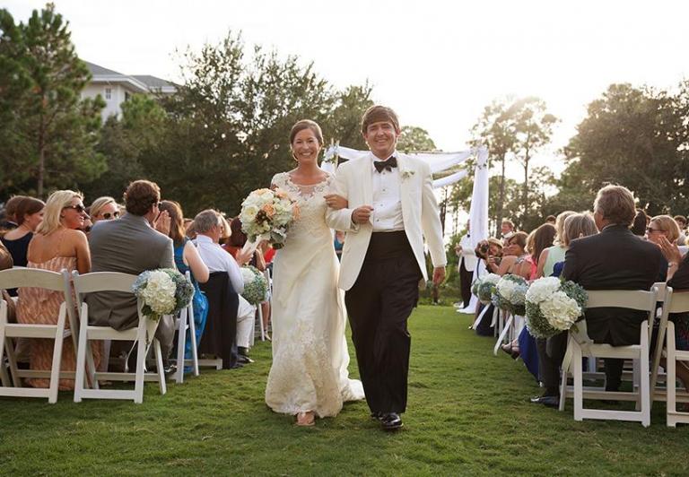 Bride and groom walking down the aisle at a garden wedding