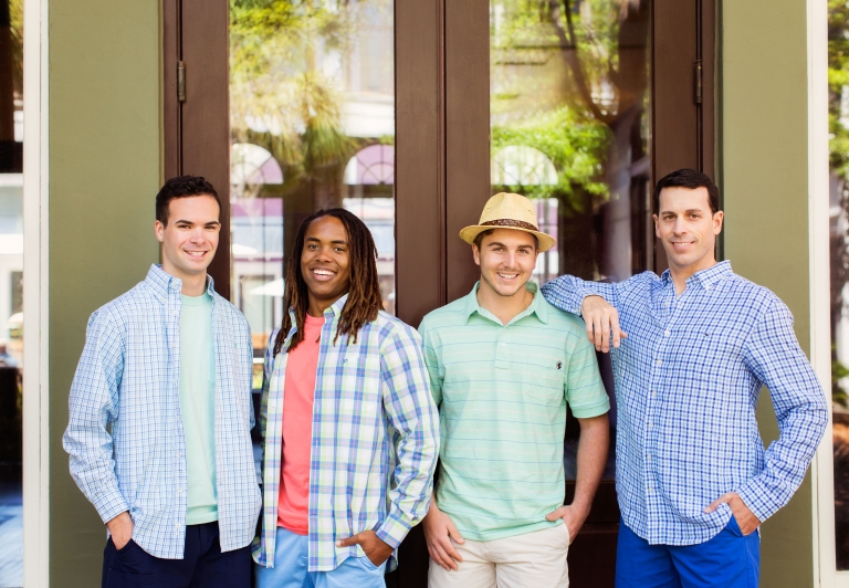 Four men standing outside of Island Clothiers