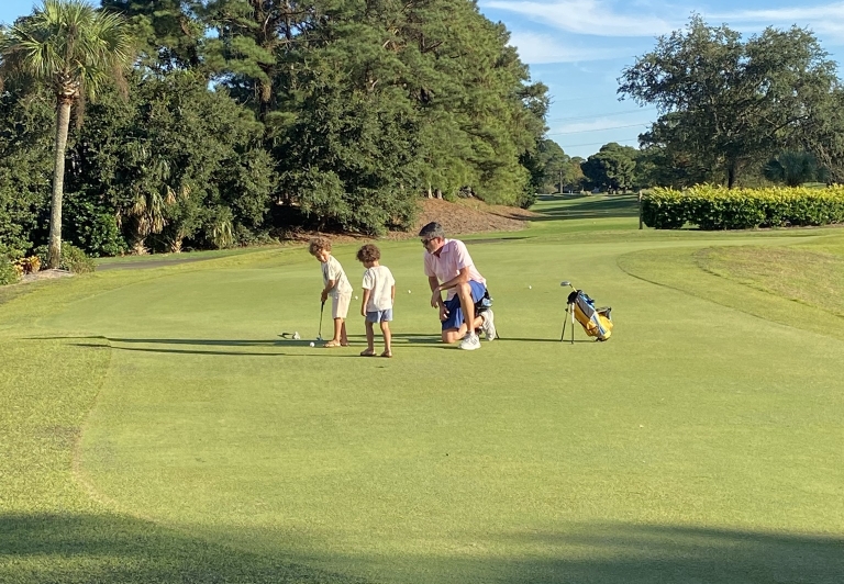 Dad playing golf with kids