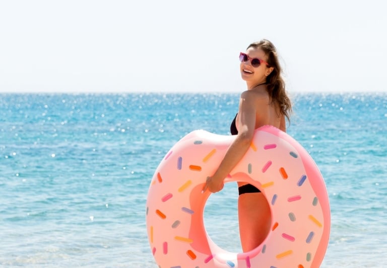 Woman holding a float on the beach