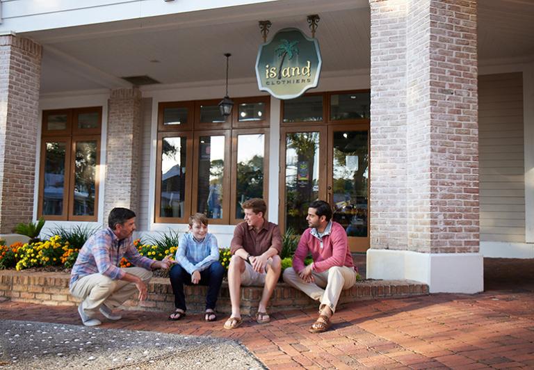Men sitting in front of store
