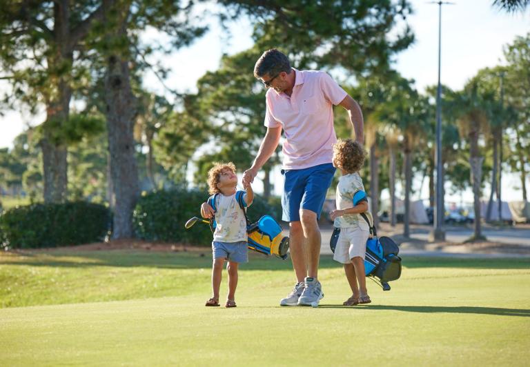 Father golfing with children.