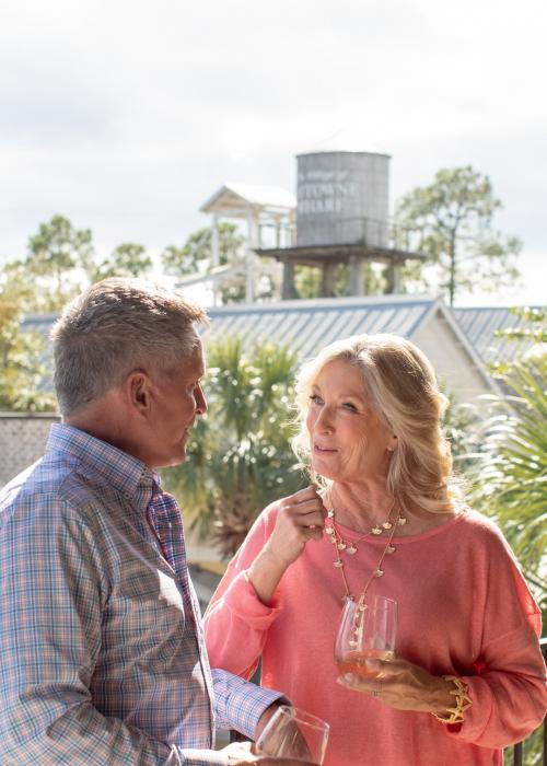 older couple enjoying a glass of wine on a balcony