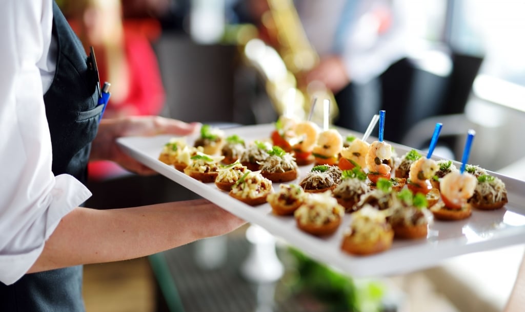 a server carries a tray of appetizers 