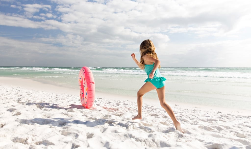 girl chasing after a pool inflatable 