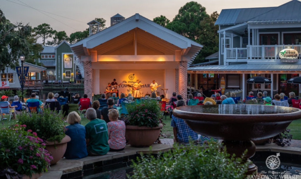 People sitting on lawn chairs watching an outdoor concert