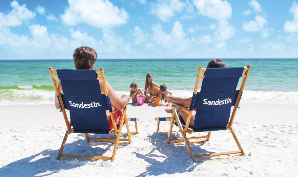 Couple on the beach with children playing in the background