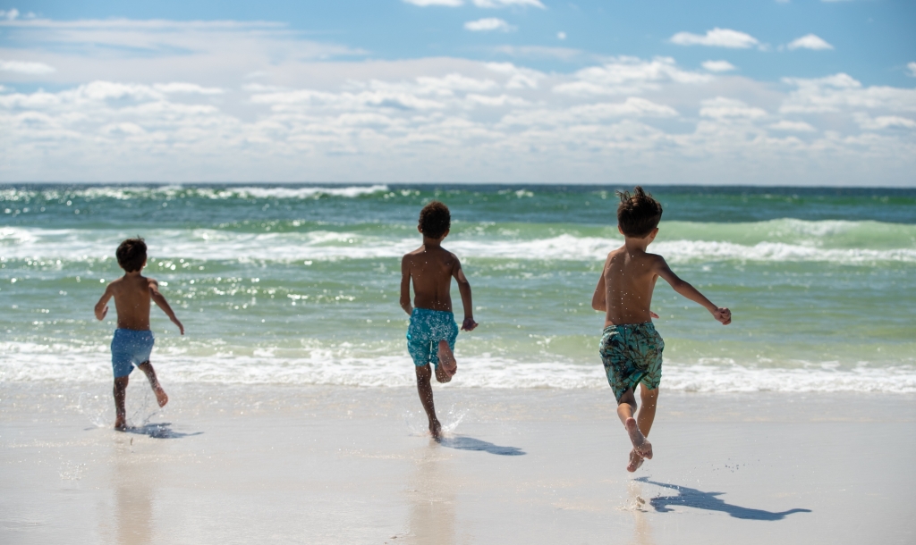 Children running towards the beach