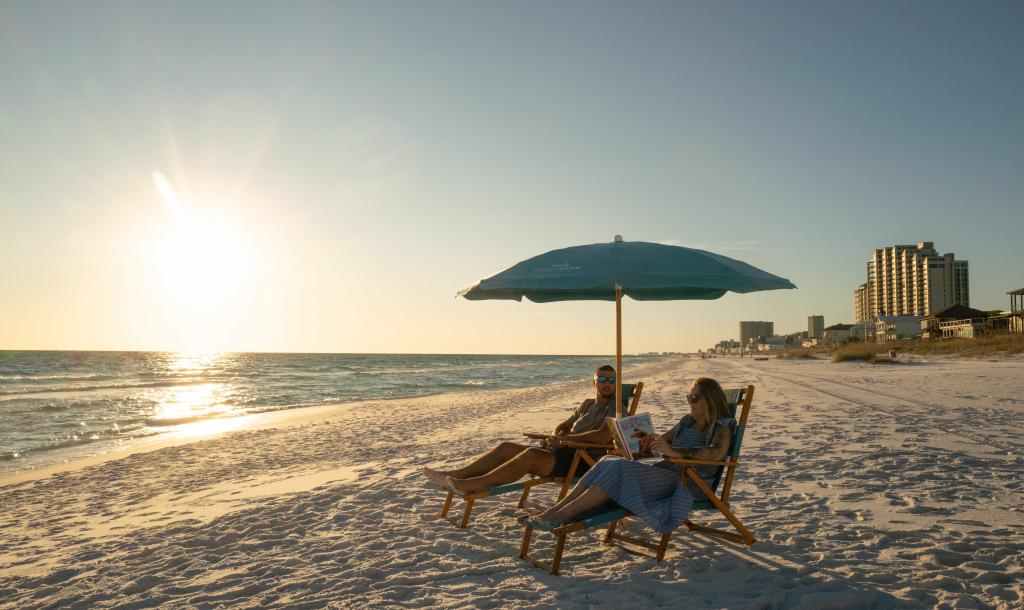 Couple enjoying the beach at sunset at the Beach Club Sandstin