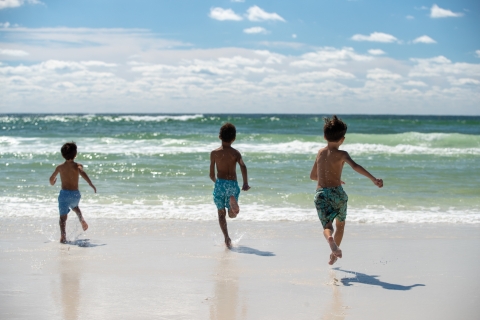 Children running towards the beach