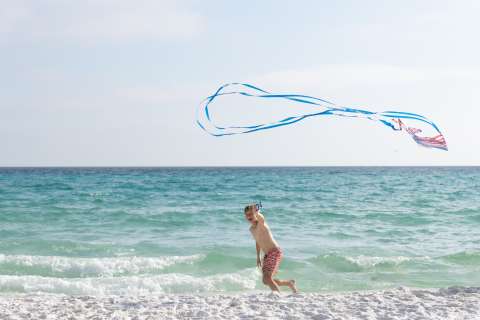 Child on a beach with a kite