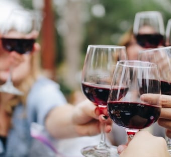 table of guests cheersing wine glasses