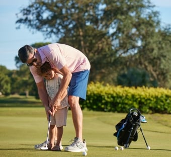 Dad teaching son golf